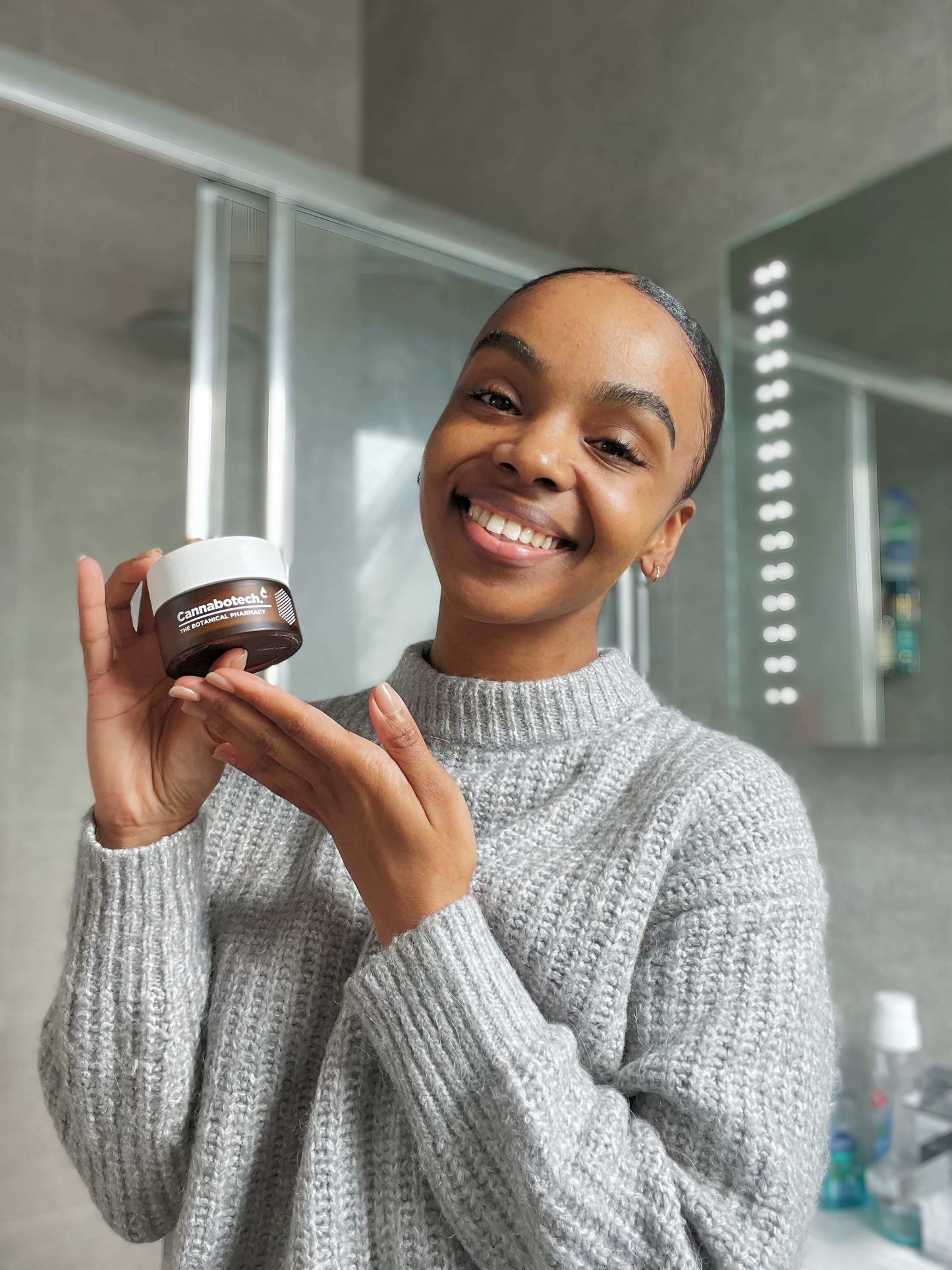 woman applying antioxidant CBD moisturiser on her face
