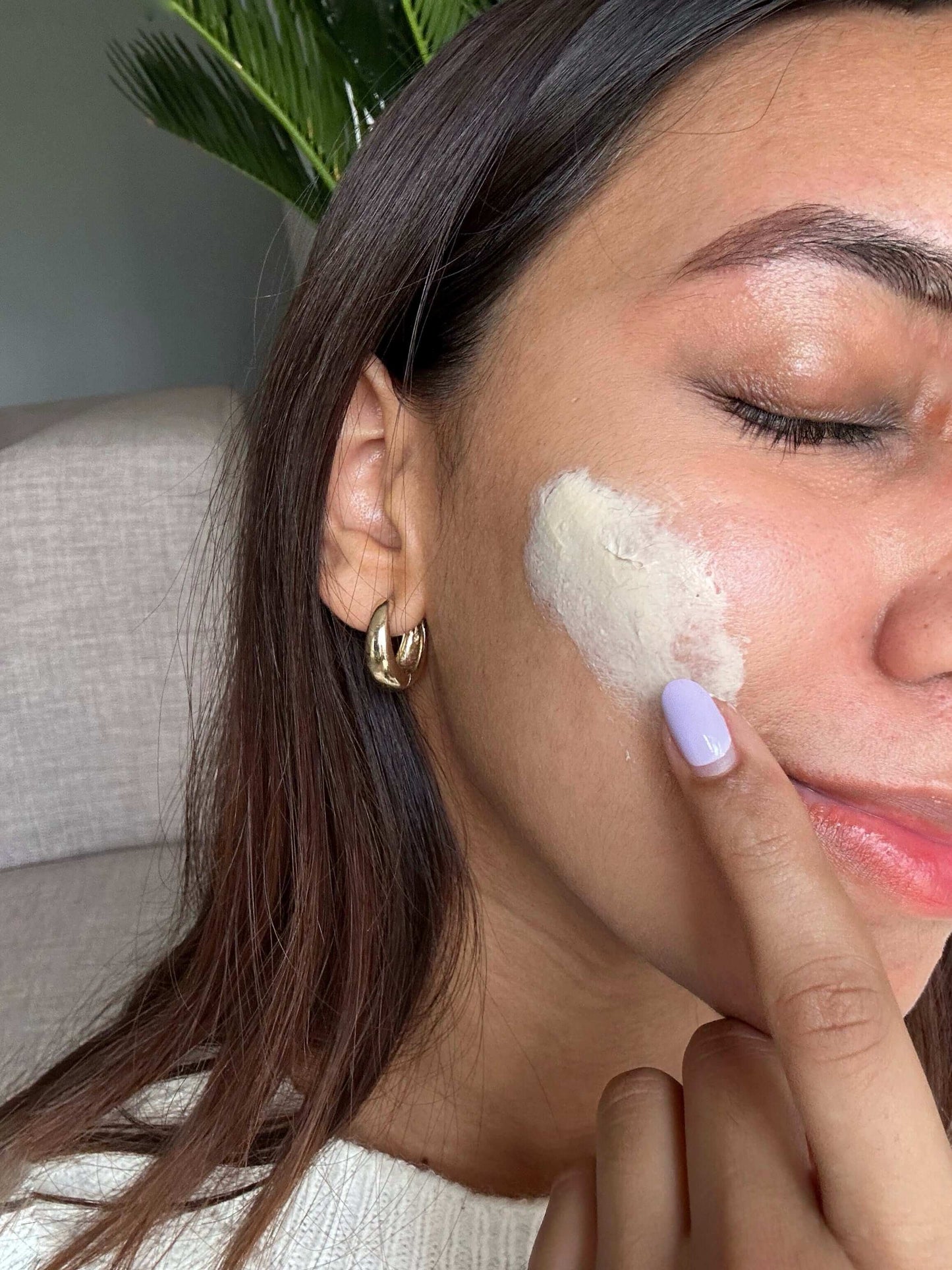 Woman applying antioxidant face cream, CBD moisturiser on her face